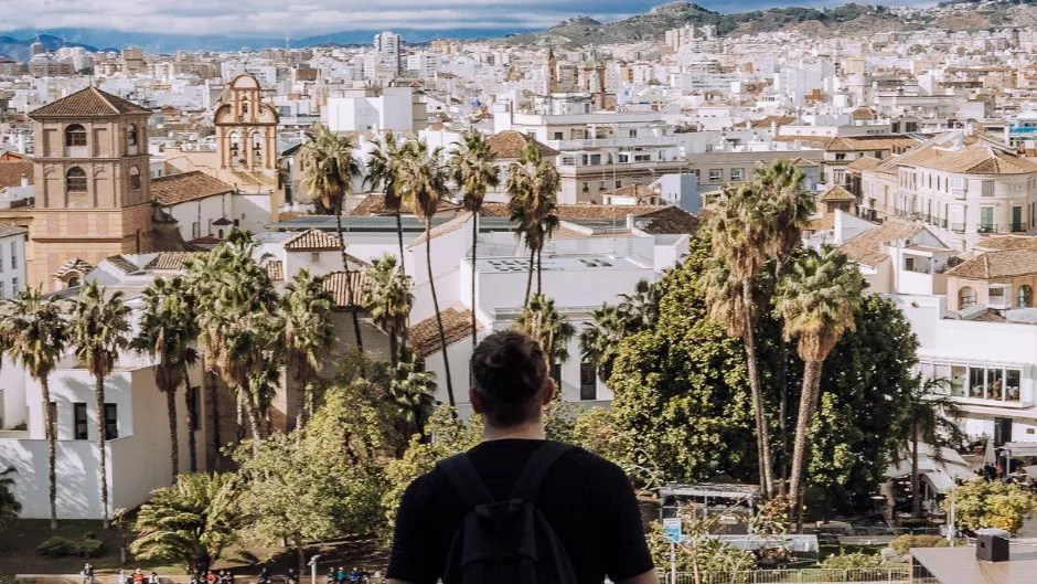 Litorale soleggiato della Costa del Sol con il Mediterraneo, un porto turistico e un paese bianco